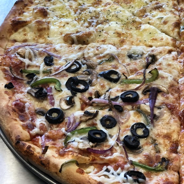 Half cheese, half supreme Kabylos Pizza with olives, mushrooms, onions, and peppers.