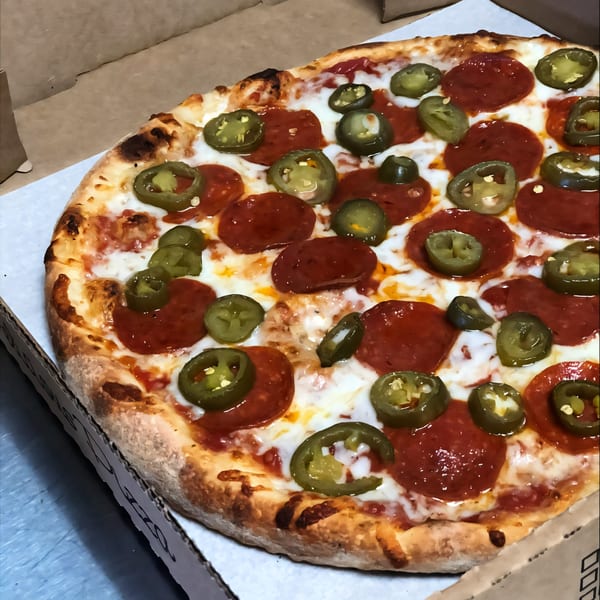 A Kabylos Pizza with pepperoni and jalapeños, fresh out of the oven in a cardboard box.